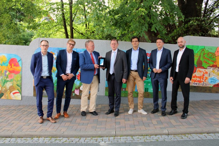Bild mit dem Thüringer Ministerpräsidenten und der Geschäftsführung von Hofmann & Sommer vor den farbigen Schautafeln zur Firmengeschichte in Königsee